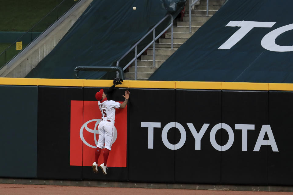 Cincinnati Reds' Nick Senzel (15) leaps at the wall as he is unable to catch the two-run home run hit by Cleveland Indians' Franmil Reyes (32) in the eighth inning during a baseball game at in Cincinnati, Tuesday, Aug. 4, 2020. (AP Photo/Aaron Doster)