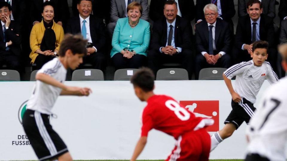 Xi Jinping y Angela Merkel en un partido de fútbol juvenil entre China y Alemania durante una visita a Berlín en 2017.