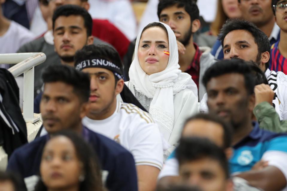 Una mujer árabe observa el partido desde la grada del estadio.