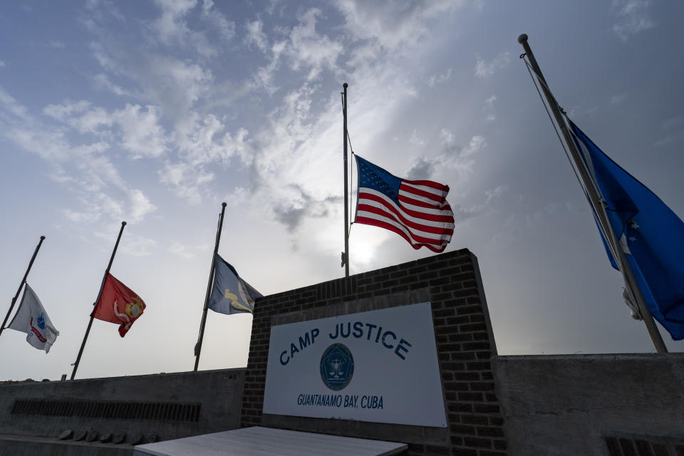 In this photo reviewed by U.S. military officials, flags fly at half-staff in honor of the U.S. service members and other victims killed in the terrorist attack in Kabul, Afghanistan, at Camp Justice, Sunday, Aug. 29, 2021, in Guantanamo Bay Naval Base, Cuba. Camp Justice is where the military commission proceedings are held for detainees charged with war crimes. (AP Photo/Alex Brandon)