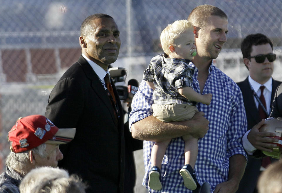 San Francisco 49ers quarterback Alex Smith, right, holds his son Hudson as he stands next to former 49ers running back Roger Craig at a groundbreaking ceremony at the construction site for the 49ers' new NFL football stadium in Santa Clara, Calif., Thursday, April 19, 2012. (AP Photo/Jeff Chiu)