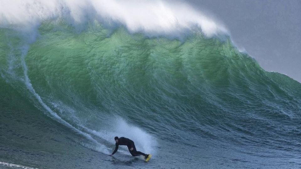 A surfer catches a wave at Sunset, an offshore surfing spot close to Hout Bay, that produces some of South Africa's biggest waves in Cape Town