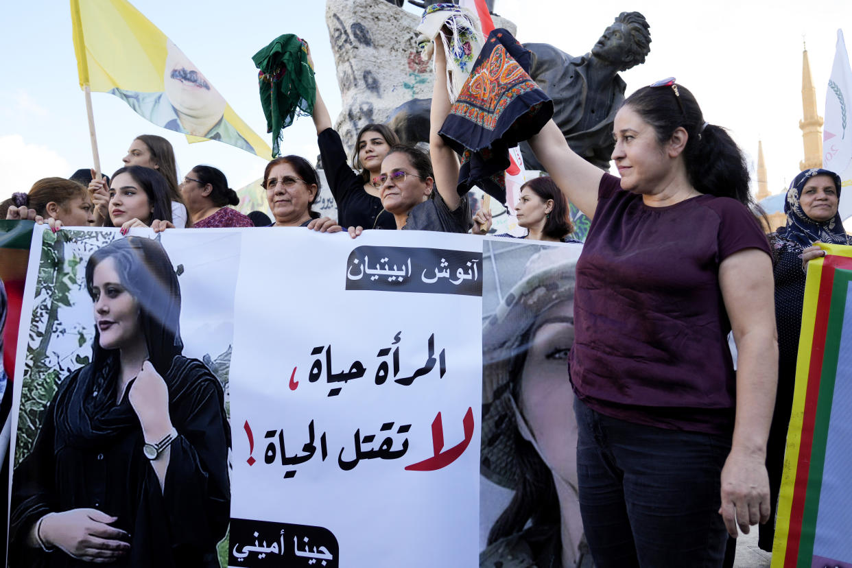 FILE - Kurdish women activists hold headscarfs and a portrait of Iranian woman Mahsa Amini, with Arabic that reads, "The woman is life, don't kill the life," during a protest against her death in Iran, at Martyrs' Square in downtown Beirut, Sept. 21, 2022. The U.S. government has imposed sanctions on Iran’s morality police after the death in custody of a woman who'd been accused of wearing her Islamic headgear too loosely. (AP Photo/Bilal Hussein, File)