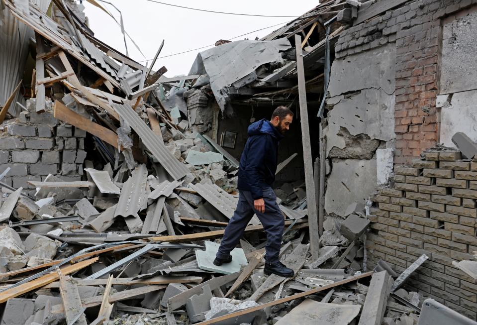 Local resident Alexander walks on the ruins of a house destroyed by recent shelling in Donetsk (Reuters)