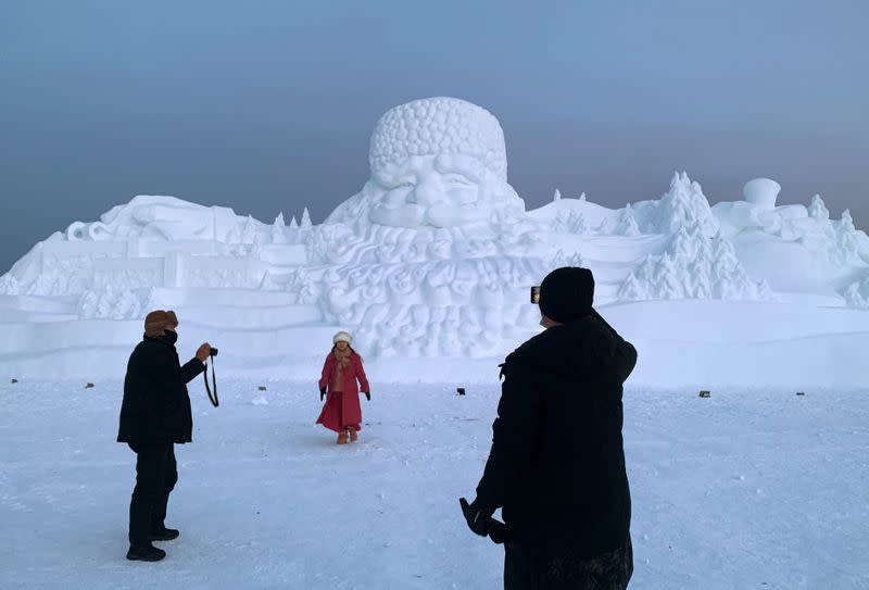 Visitors take pictures in front of a giant snow sculpture in the shape of a Santa Claus, at a Christmas theme park on the outskirts of Mohe, China's northernmost city in Heilongjiang province