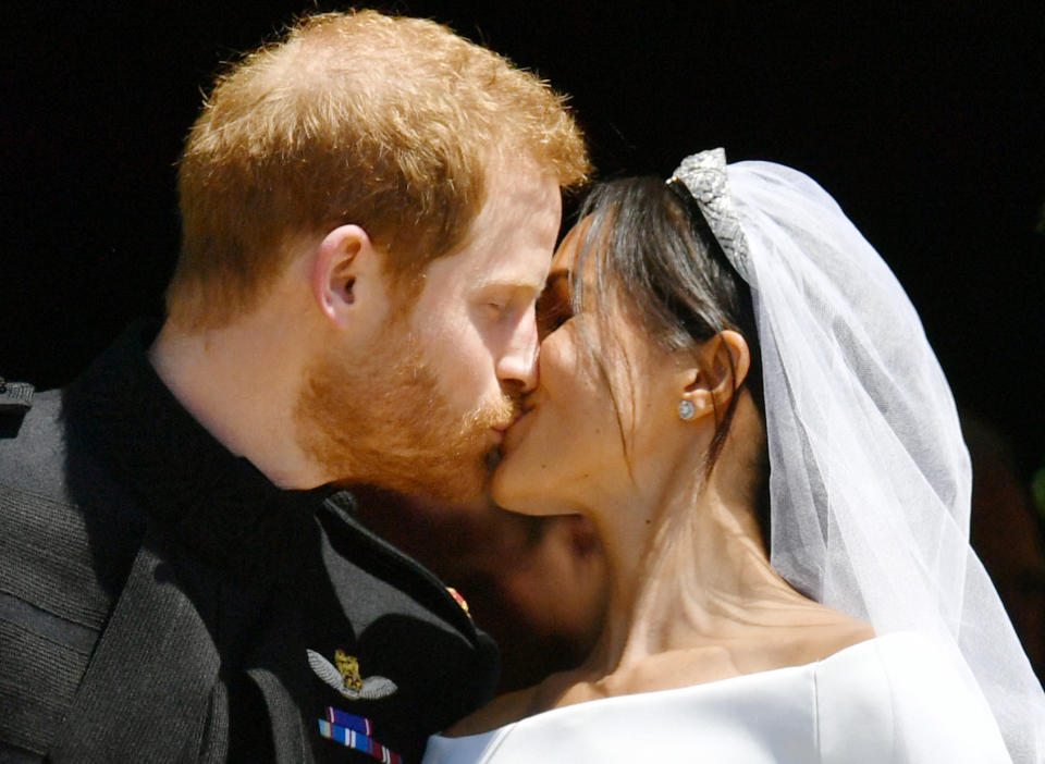 Prince Harry and Meghan Markle share a kiss.