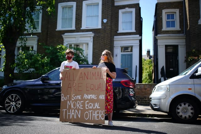 Protesters hold a sign with a quote from George Orwell’s Animal Farm outside the north London home of Dominic Cummings 