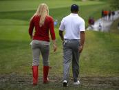 U.S. golfer Tiger Woods walks with his girlfriend Lindsey Vonn after losing his rain delayed Foursome match during the 2013 Presidents Cup golf tournament at Muirfield Village Golf Club in Dublin, Ohio October 6, 2013. REUTERS/Jeff Haynes (UNITED STATES - Tags: SPORT GOLF)