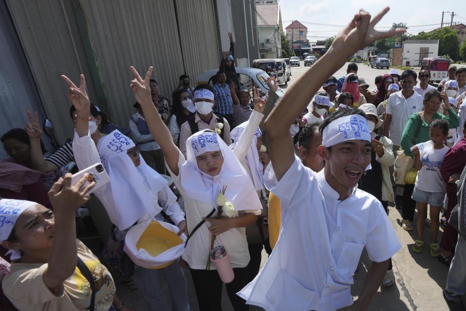 An environmental activist, front right, raises his V-sign together with supporters as he leads a protest near Phnom Penh Municipality Court, in Phnom Penh, Cambodia, Tuesday, July 2, 2024. Ten members of a nonviolent environmental activist group in Cambodia were convicted on Tuesday on charges of conspiracy to commit a crime, receiving prison sentences of six years each. (AP Photo/Heng Sinith)