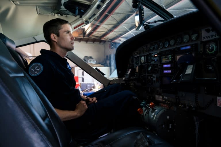Le pilote Ryan Olson inspecte le Cessna 208B Grand Caravan de Xwing, qui a été équipé de systèmes informatiques pour le rendre autonome (AFP/Nick Otto)
