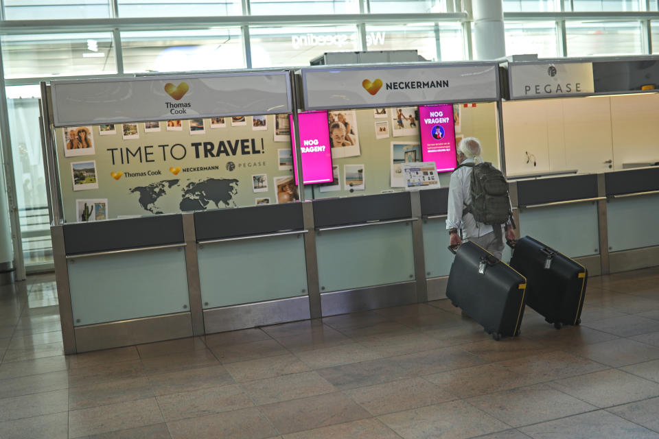 A traveller stands by an empty service counter of Neckermann, part of Thomas Cook tour company, at the Brussels international airport in Brussels, Monday, Sept. 23, 2019. British tour company Thomas Cook collapsed early Monday after failing to secure emergency funding, leaving tens of thousands of vacationers stranded abroad. (AP Photo/Francisco Seco)