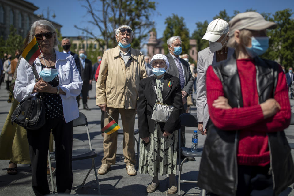 Lithuanian people attend a commemoration in Vilnius, Lithuania, Monday, June 14, 2021, marking the mass deportation 80 years ago by the Soviet Union that was occupying the Baltic nation. Deportation started on June 14, 1941, where some 280,000 people were deported to Siberian gulags, a year after Soviet troops had occupied Lithuania. (AP Photo/Mindaugas Kulbis)