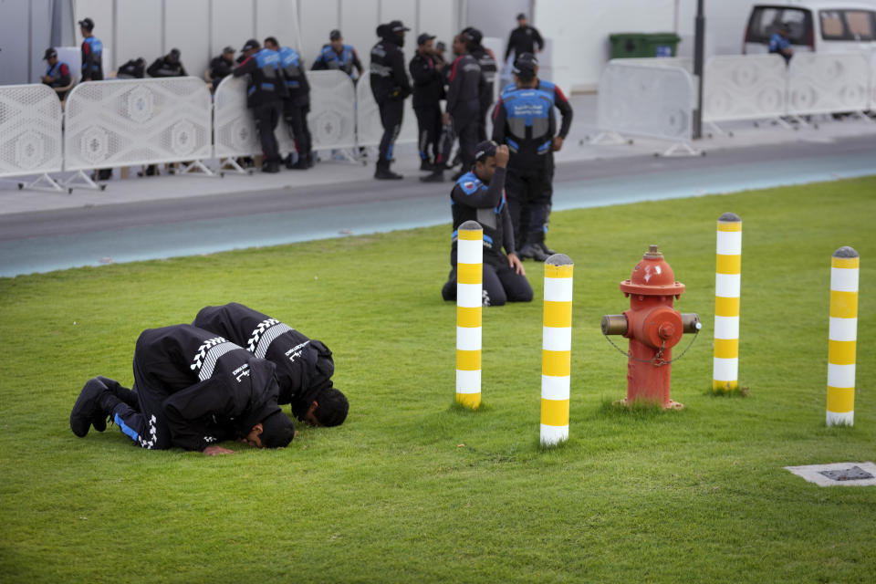 Police pray as they wait ahead of the World Cup quarterfinal soccer match between Morocco and Portugal, at Al Thumama Stadium in Doha, Qatar, Saturday, Dec. 10, 2022. (AP Photo/Jorge Saenz)