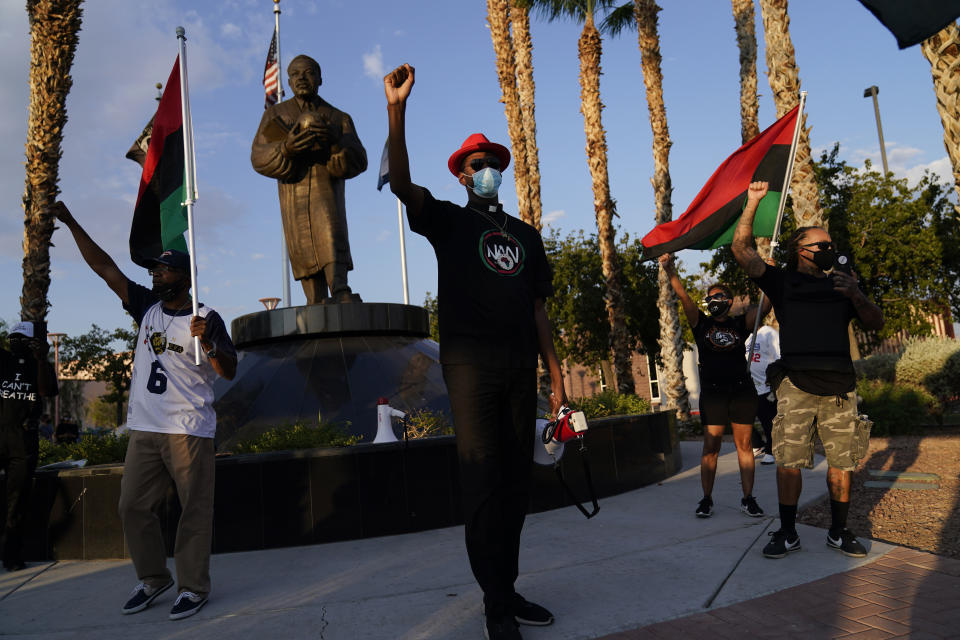 FILE - Stretch Sanders, center, leads a "March on Washington" rally for police accountability and reform at a statue of the Rev. Martin Luther King Jr., Friday, Aug. 28, 2020, in North Las Vegas, Nev. The rally was held on the 57th anniversary of the Rev. Martin Luther King Jr.'s "I Have A Dream" speech. (AP Photo/John Locher, File)