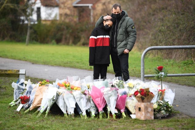 Two people look at flowers for Captain Sir Tom Moore