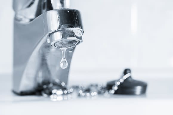 A drop of water dripping from a faucet.