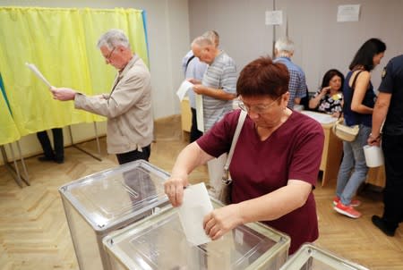 A voter casts her ballot at a polling station during a parliamentary election in Kiev