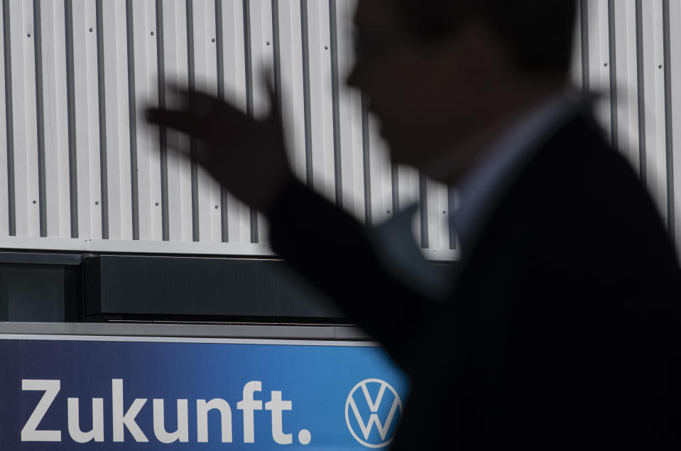 Reinhard de Vries, Managing Director technology and logistic Volkswagen Saxony, explains details of the production restart at the plant of the German manufacturer Volkswagen AG (VW) in Zwickau, Germany, Thursday, April 23, 2020. The sign reads: 'Future'. Volkswagen starts with step-by-step resumption of production. The car company are completely converting the plant in Zwickau from 100 percent combustion engine to 100 percent electric. (AP Photo/Jens Meyer)