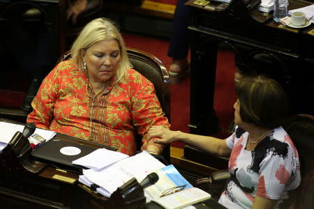 Lawmaker Alicia Terada (R) comforts her colleague Elisa Carrio during a debate at the Argentine Congress in Buenos Aires, Argentina December 18, 2017. REUTERS/Agustin Marcarian