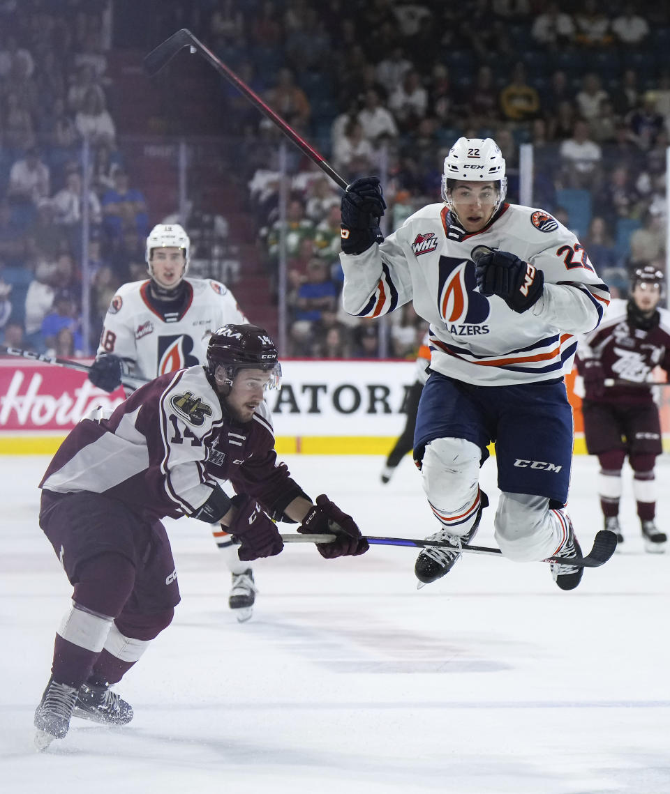 Kamloops Blazers' Daylan Kuefler, right, tries to jump past Peterborough Petes' Quinton Page during third-period CHL Memorial Cup hockey game action in Kamloops, British Columbia, Sunday, May 28, 2023. (Darryl Dyck/The Canadian Press via AP)