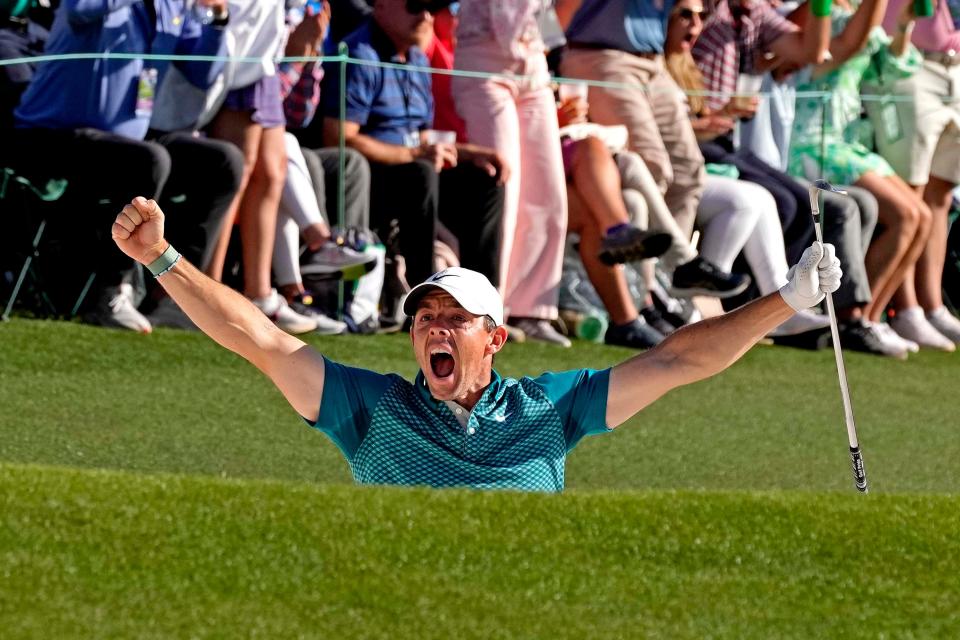Rory McIlroy celebrates after holing out from a bunker on the 18th hole during the final round of the Masters.