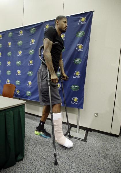 Paul George is using crutches to walk after breaking his right leg. (AP)