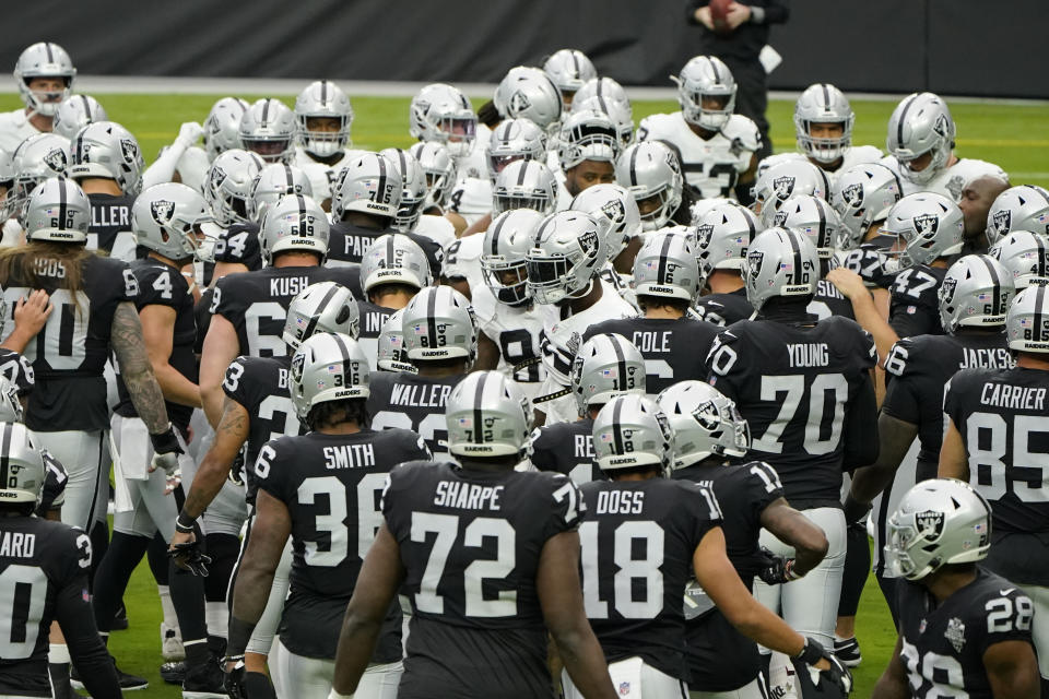 Las Vegas Raiders players gather during an NFL football training camp practice Friday, Aug. 28, 2020, in Las Vegas. (AP Photo/John Locher)