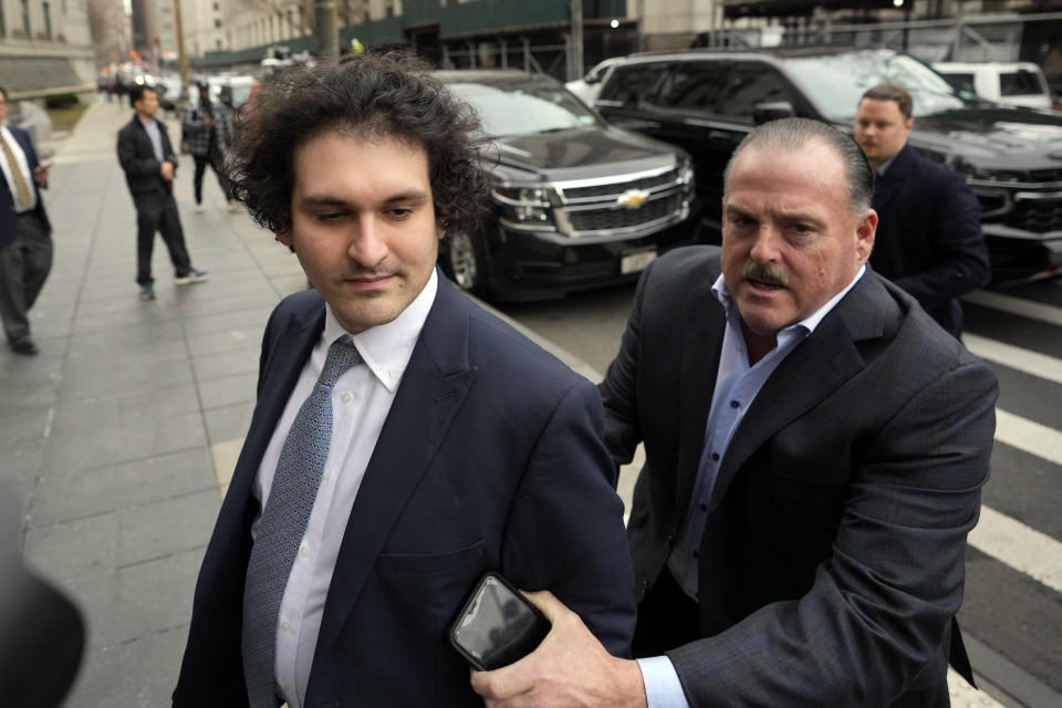 FILE - FTX founder Sam Bankman-Fried, left, arrives at Manhattan federal court on Feb. 16, 2023, in New York. In a proposal submitted Friday, March 3, 2023, prosecutors and attorneys for Bankman-Fried are requesting the disgraced cryptocurrency entrepreneur be allowed a flip-phone or another device that’s not a smartphone while on bail. (AP Photo/John Minchillo, File)