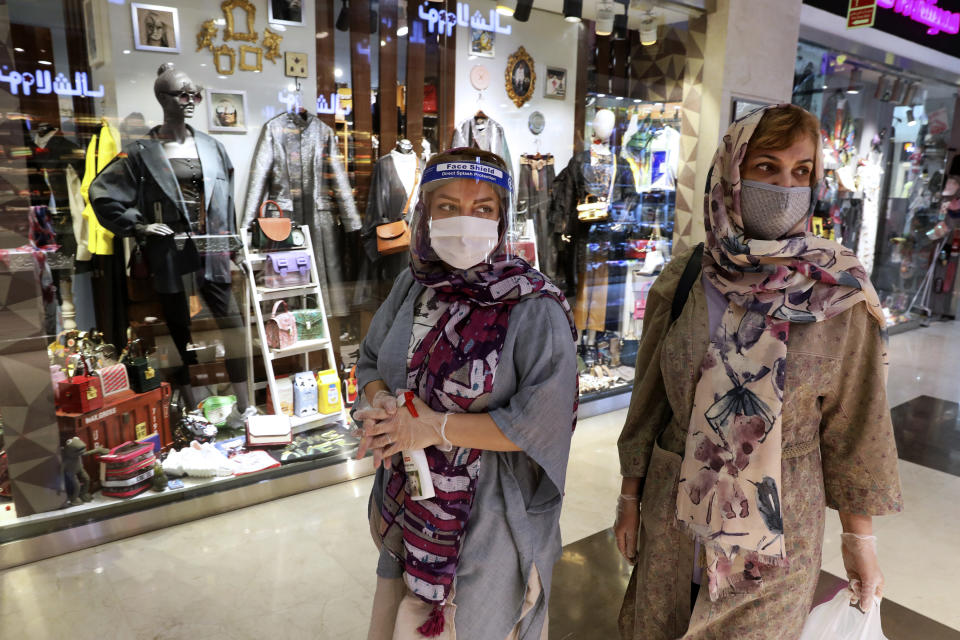 Women wearing protective face masks and gloves to help prevent the spread of the coronavirus shop at the Kourosh Shopping Center in Tehran, Iran, Monday, April 20, 2020. Iran on Monday began opening intercity highways and major shopping centers to stimulate its sanctions-choked economy, gambling that it has brought under control its coronavirus outbreak — one of the worst in the world — even as some fear it could lead to a second wave of infections. (AP Photo/Vahid Salemi)