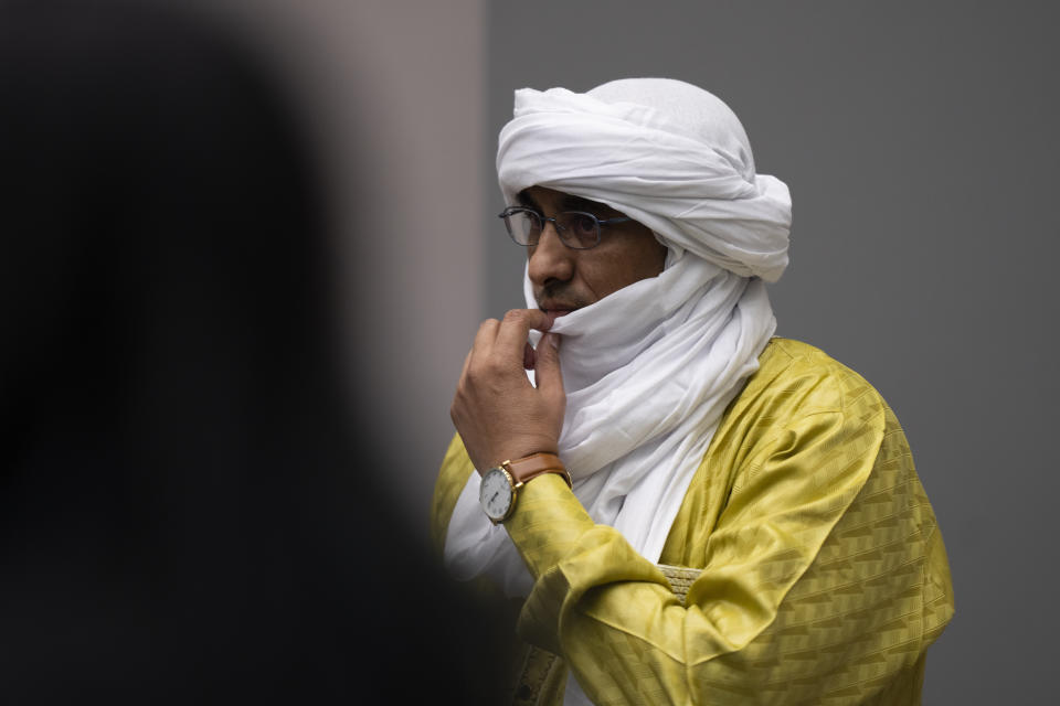 Al Hassan Ag Abdoul Aziz Ag Mohamed Ag Mahmoud se pone en pie a la entrada de los jueces en la sala de la Corte Penal Internacional en La Haya, Holanda, el 26 de junio de 2024, donde fue juzgado por su implicación en el reinado de terror desatado por insurgentes ligados a Al Qaeda en Tombuctú, Malí. (AP Foto/Peter Dejong, Pool)