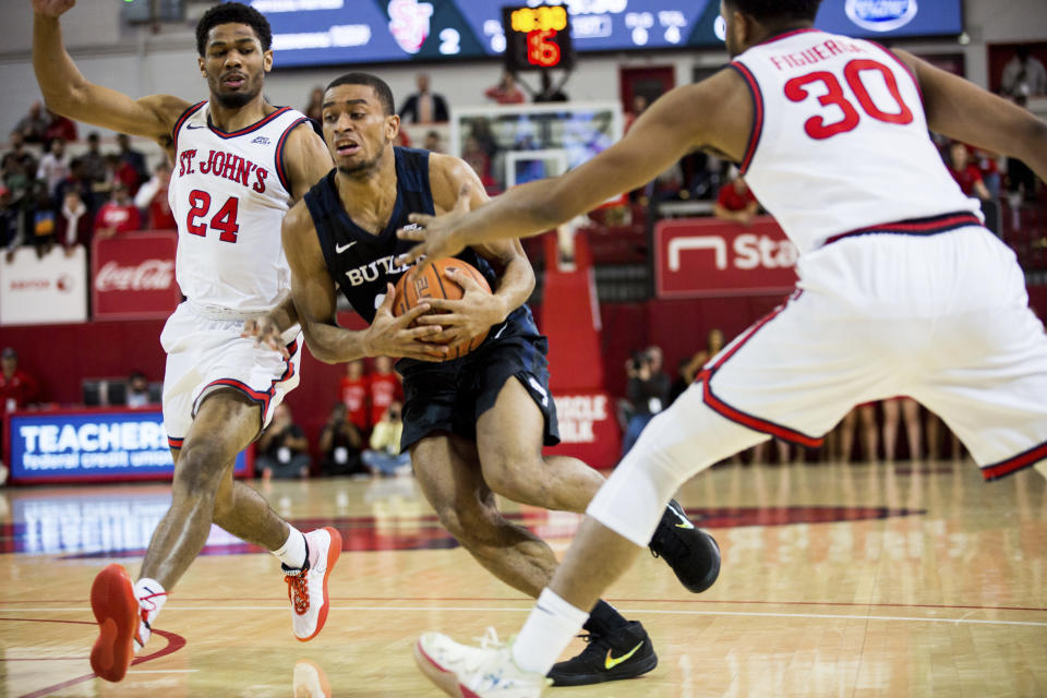 Butler guard Aaron Thompson (2) pushes through St. John's guards Nick Rutherford (24) and LJ Figueroa (30) during the first half of NCAA college basketball game Tuesday, Dec. 31, 2019, in New York. (AP Photo/Julius Constantine Motal)