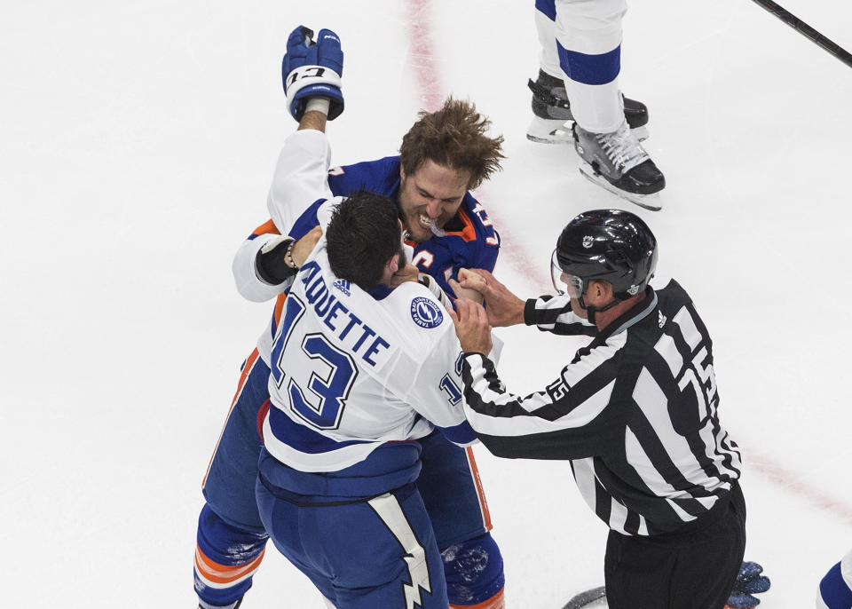 Tampa Bay Lightning center Cedric Paquette (13) and New York Islanders' Anders Lee (27) fight during the second period of Game 3 of the NHL hockey Eastern Conference final, Friday, Sept. 11, 2020, in Edmonton, Alberta. (Jason Franson/The Canadian Press via AP)