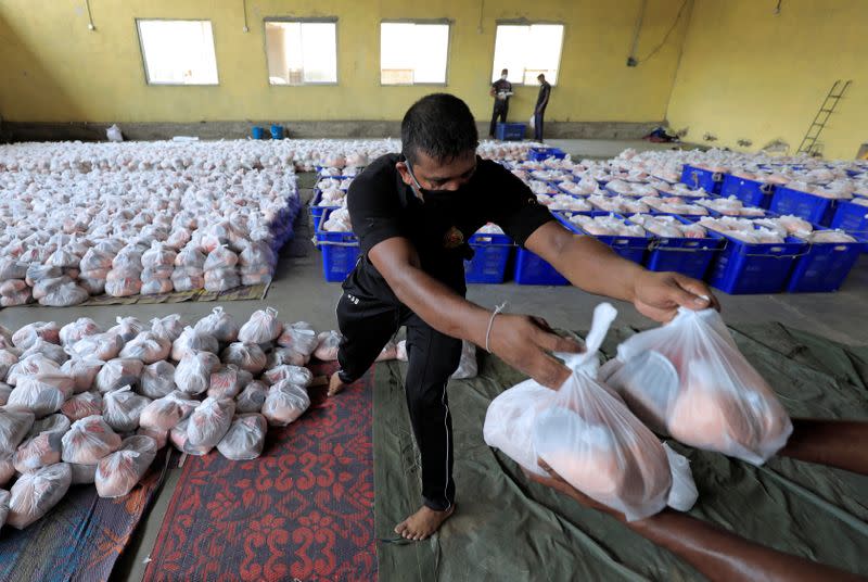 Sri Lankan civil Defence Force members load the essential food items packs into a truck to sell for low cost at a warehouse after the government imposed the nationwide curfew, in Colombo