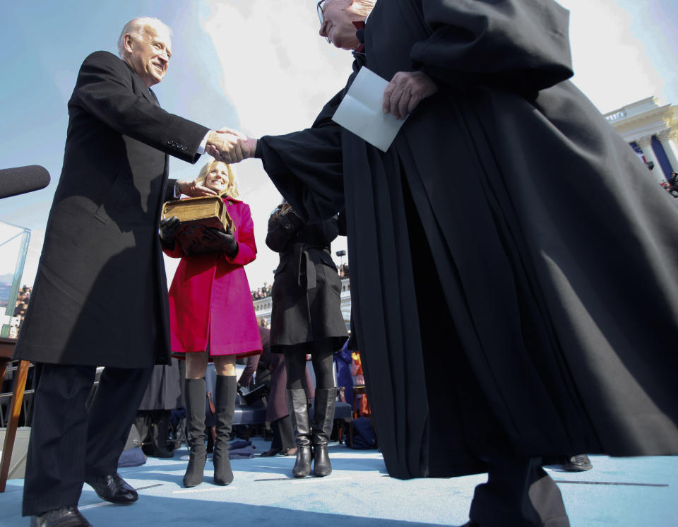 FILE - In this Tuesday, Jan. 20, 2009 file photo, Vice President Joseph Biden, left, shakes hands with Supreme Court Associate Justice John Paul Stevens, following his swearing in ceremony at the U.S. Capitol in Washington. While many presidents have used Bibles for their inaugurations, the Constitution does not require the use of a specific text and specifies only the wording of president’s oath. (Chuck Kennedy/MCT via AP, Pool)