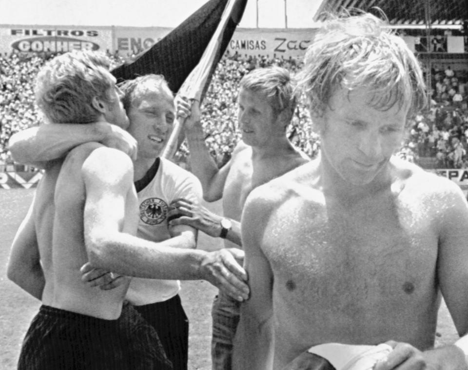 FILE - In this June 14, 1970 file photo German team captain Uwe Seeler, centre, hugs team mate Klaus Fichtel after the 3-2 victory over England, while England's Francis Lee leaves the pitch in Leon, Mexico. The Germans recovered from a 2-0 deficit to officially end England's reign as World Cup champions in the quarterfinals of the 1970 tournament in Mexico. (AP Photo/Lohmann, File)