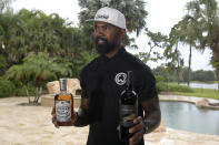 Former NFL football player Charles Woodson shows bottles of his own bourbon and wine while reflecting on his life and career as he prepares for induction into the NFL Hall of Fame, during an interview at his home Tuesday, June 15, 2021, in Orlando, Fla. (AP Photo/Phelan M. Ebenhack)