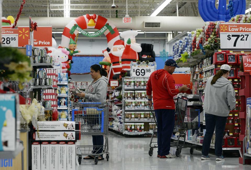 Customers shop for Christmas ornaments at a Walmart store in the Porter Ranch section of Los Angeles in this November 26, 2013, file photo. With growing online competition, no fashion must-haves and weak consumer confidence, most U.S. retailers will have to offer both big discounts and stellar service to get consumers to spend freely, according to retail analysts who joined Reuters reporters on visits to stores in New York, New Jersey, California and Illinois ahead of the holiday season. REUTERS/Kevork Djansezian/Files (UNITED STATES - Tags: BUSINESS ANNIVERSARY)