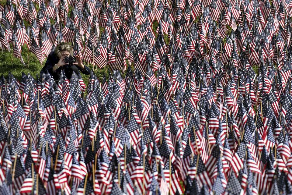 <p>A woman photographs American flags on Boston Common in Boston, which are placed there for Memorial Day on May 24, 2018. The solemn display of tens of thousands of U.S. flags that first appeared on Boston Common a decade ago to honor service members who have died defending the nation is slowly becoming a national movement. The flag gardens, as they are known, can be seen this weekend in Texas, Louisiana, Ohio and New York. (Photo: Elise Amendola/AP) </p>