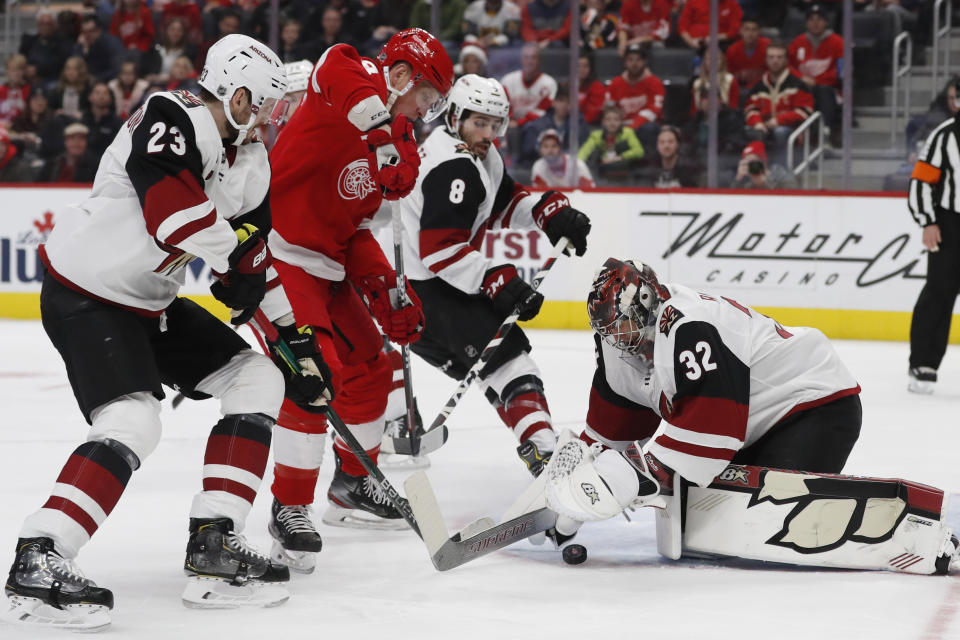 Arizona Coyotes goaltender Antti Raanta (32) falls on the puck hit by Detroit Red Wings left wing Justin Abdelkader (8) during the first period of an NHL hockey game, Sunday, Dec. 22, 2019, in Detroit. (AP Photo/Carlos Osorio)