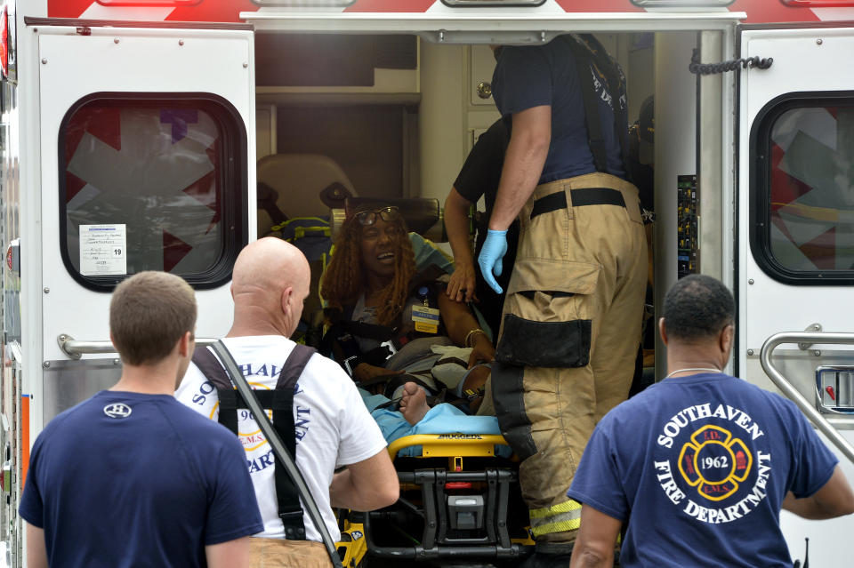 A Walmart employee receives medical attention after a shooting at the store, Tuesday, July 30, 2019, in Southaven, Miss. A gunman fatally shot two people and wounded a police officer before he was shot and arrested Tuesday at the Walmart in northern Mississippi, authorities said. (AP Photo/Brandon Dill)