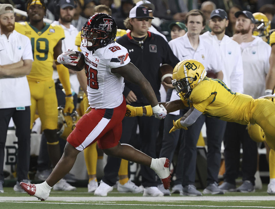 Texas Tech running back Tahj Brooks (28) runs past Baylor cornerback Chateau Reed (21) in the first half of an NCAA college football game, Saturday, Oct. 7, 2023, in Waco, Texas. (Jerry Larson/Waco Tribune-Herald, via AP)