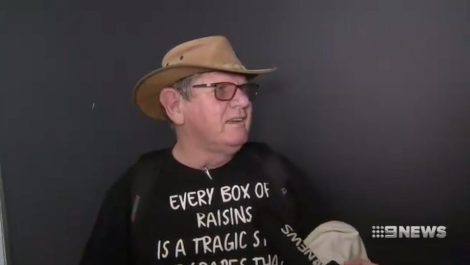 A man in a hat speaks on camera.