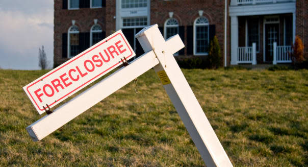 Foreclosure sign in front of a large single family home
