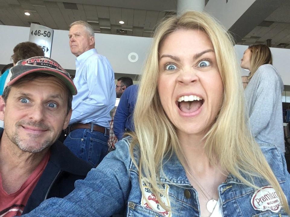 The author and her husband at an airport making silly faces at the camera.