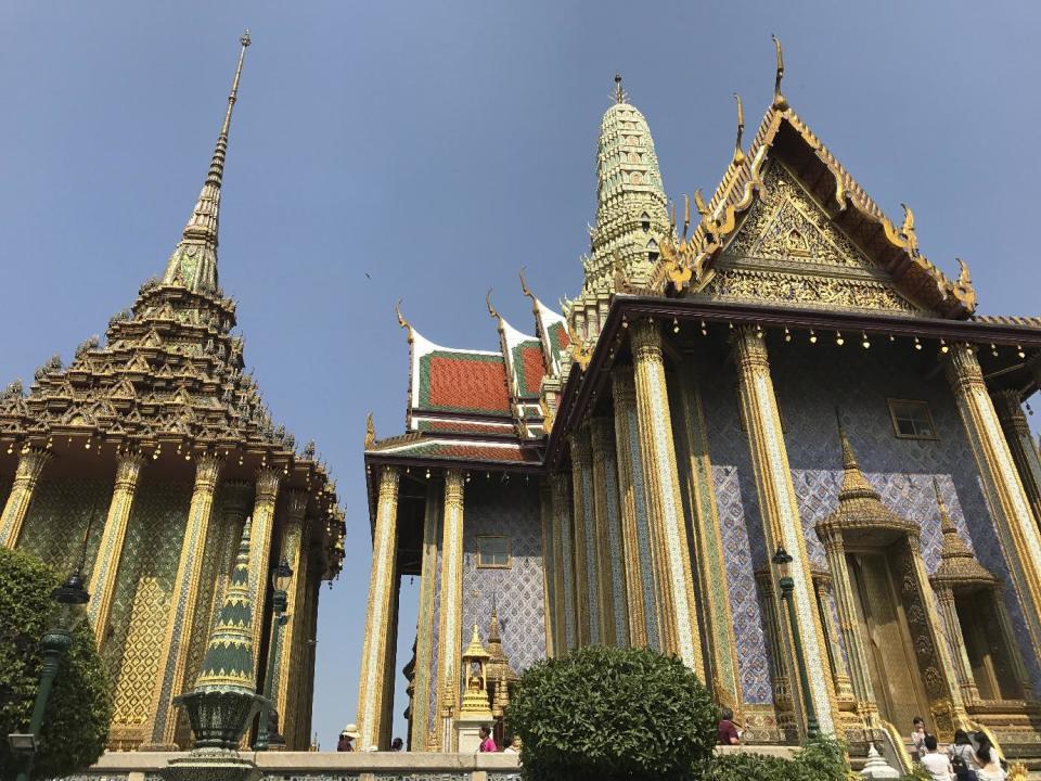 This Dec. 9, 2016 photo shows two ornate buildings at Wat Phra Kaew, or the Temple of the Emerald Buddha, in Bangkok. They are just across from the main structure housing the most sacred statue in Thailand, the Emerald Buddha, which is actually carved of jade and surprisingly small. (AP Photo/Courtney Bonnell)