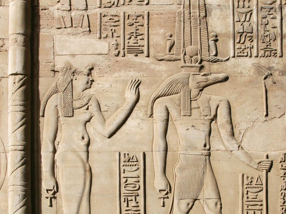 A fresque shows representation of Sobek surrounded by hieroglyphs. Behind sohbek, a woman is shown.