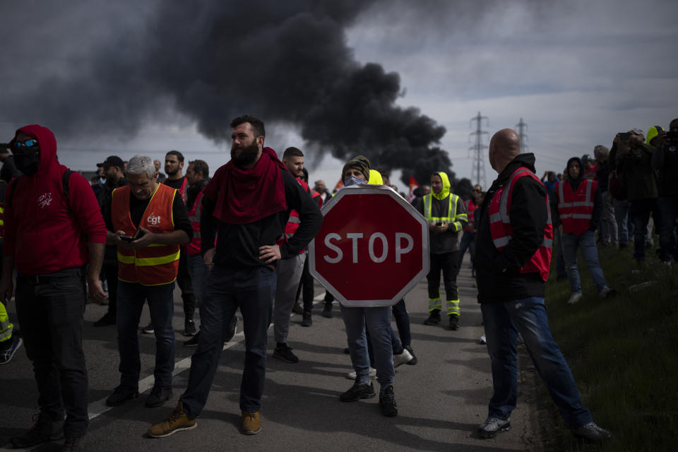 Oil workers block the access to an oil depot in Fos-sur-Mer, southern France, Tuesday, March 21, 2023. The bill pushed through by President Emmanuel Macron without lawmakers' approval still faces a review by the Constitutional Council before it can be signed into law. Meanwhile, oil shipments in the country were disrupted amid strikes at several refineries in western and southern France. (AP Photo/Daniel Cole)