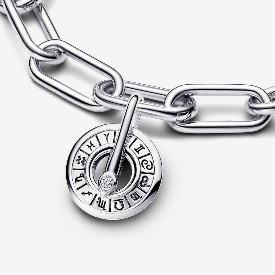 silver charm with zodiac sign engravings