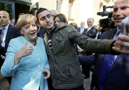 FILE PHOTO: Syrian refugee Anas Modamani takes a selfie with German Chancellor Angela Merkel outside a refugee camp near the Federal Office for Migration and Refugees after registration at Berlin's Spandau district, Germany September 10, 2015. REUTERS/Fabrizio Bensch/File Photo