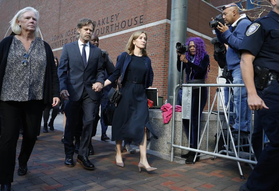 Felicity Huffman leaves federal court with her husband William H. Macy after she was sentenced in a nationwide college admissions bribery scandal, Friday, Sept. 13, 2019, in Boston. (AP Photo/Michael Dwyer)